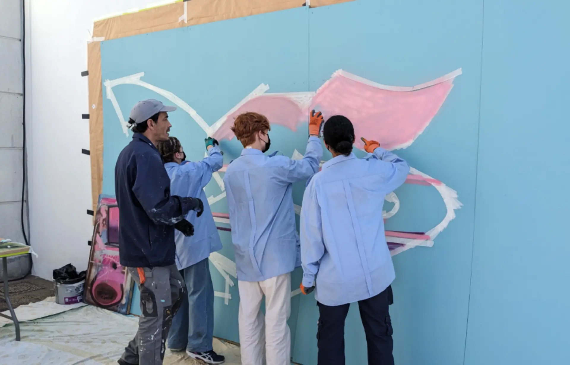 atelier grafiti avec 3 jeunes en train d'apprendre le grafiti