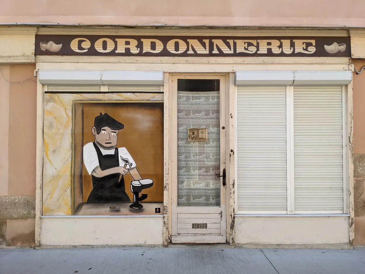 une peinture dun cordonnier travaillant devant l'enseigne de l'ancienne cordonnerie de Paimboeuf