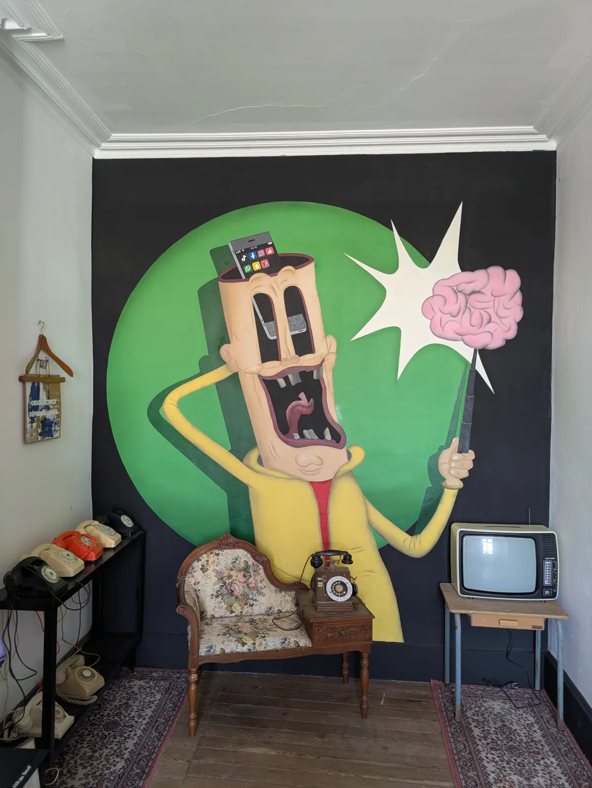 Fresque murale pop art représentant un personnage tenant un cerveau et un smartphone, dans les locaux de l’association 13 Arts – exposition street art et culture urbaine