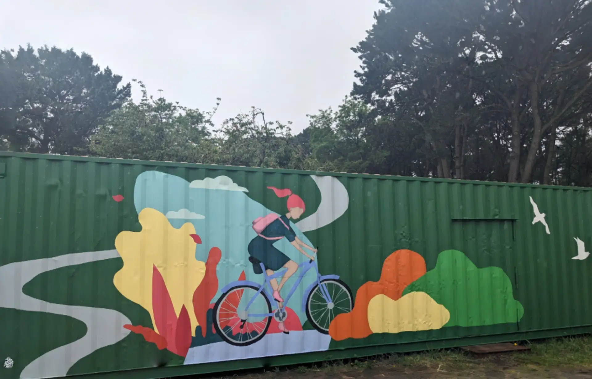 conteneur avec une peinture muticouleur d'une femme a velo